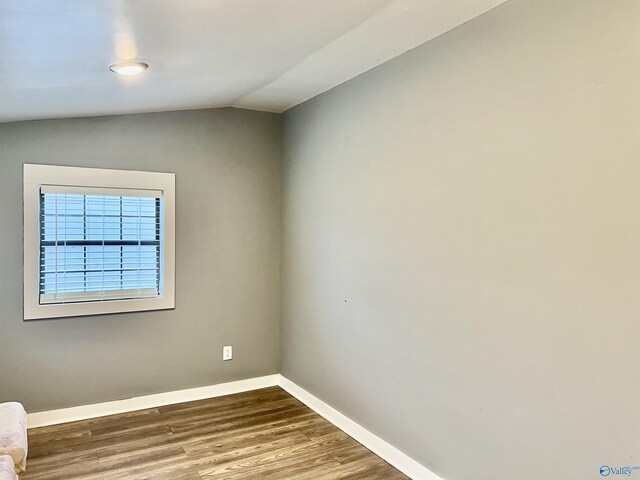 empty room featuring hardwood / wood-style floors and vaulted ceiling