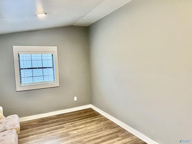 unfurnished room with lofted ceiling and hardwood / wood-style flooring