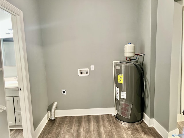 utility room with electric water heater and sink