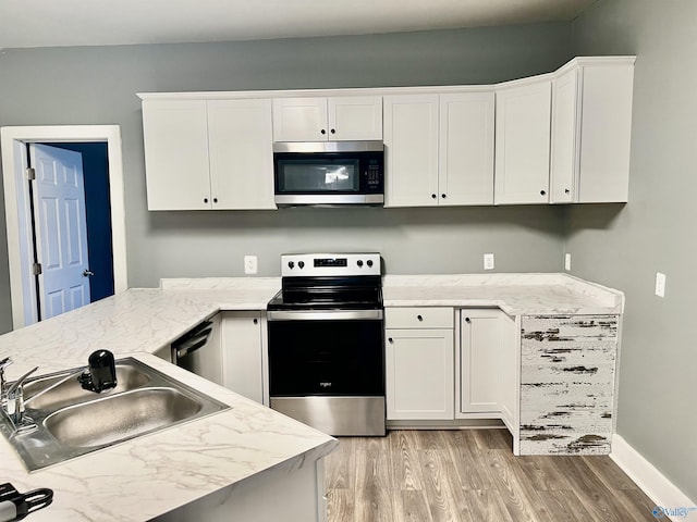 kitchen featuring white cabinets, sink, light wood-type flooring, and stainless steel appliances