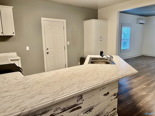 kitchen with white cabinetry, sink, a wall mounted air conditioner, and dark hardwood / wood-style floors