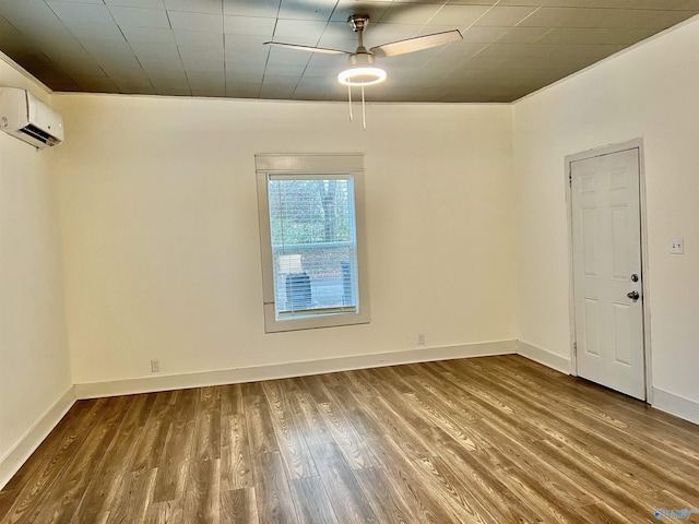 empty room featuring an AC wall unit, ceiling fan, and hardwood / wood-style floors