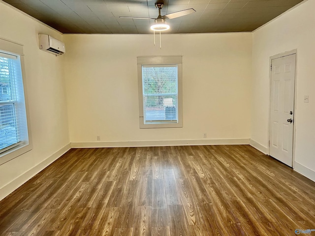 empty room with a wall unit AC, ceiling fan, plenty of natural light, and dark wood-type flooring