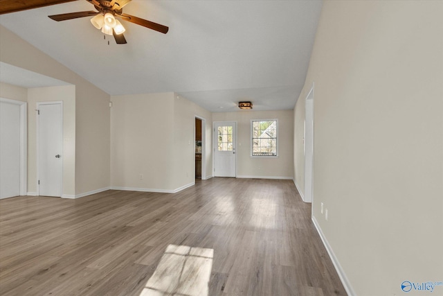 unfurnished living room with a ceiling fan, baseboards, and wood finished floors