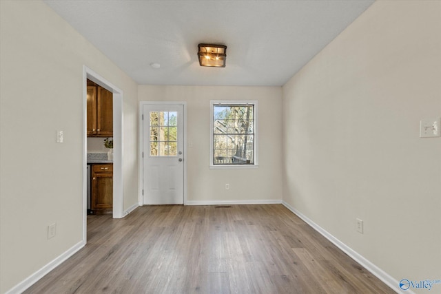 interior space with baseboards and wood finished floors