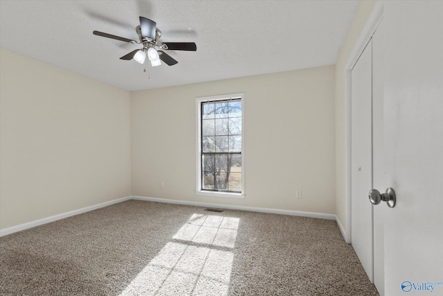 unfurnished bedroom with carpet floors, a closet, a textured ceiling, and baseboards