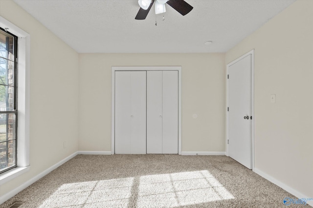 unfurnished bedroom featuring carpet floors, multiple windows, and baseboards