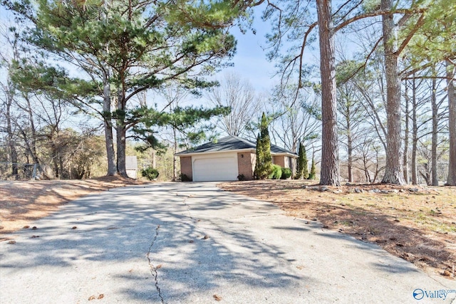 view of front of home with a garage, driveway, and brick siding