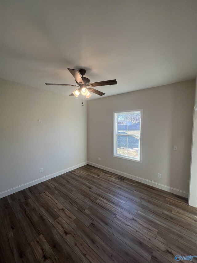 spare room featuring dark hardwood / wood-style flooring and ceiling fan