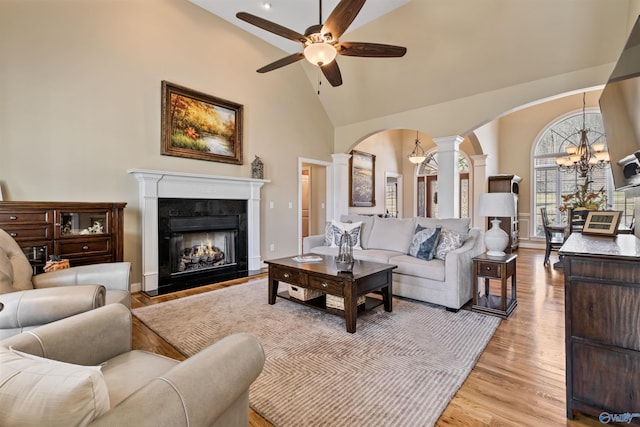 3602 Beason Cove Rd, Steele, AL 35987 - living room with light wood-style floors, ceiling fan with notable chandelier, arched walkways, ornate columns, and a high end fireplace