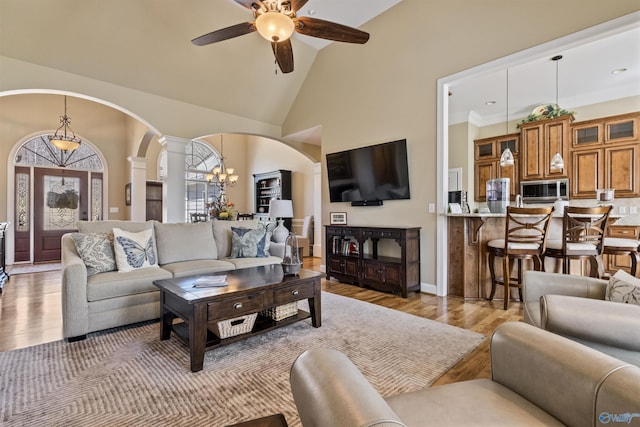 3602 Beason Cove Rd, Steele, AL 35987 - living room featuring light wood-style flooring, arched walkways, ceiling fan with notable chandelier, and decorative columns