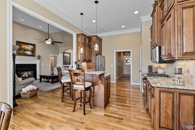 3602 Beason Cove Rd, Steele, AL 35987 - kitchen with brown cabinetry, ceiling fan, a breakfast bar area, and stainless steel appliances