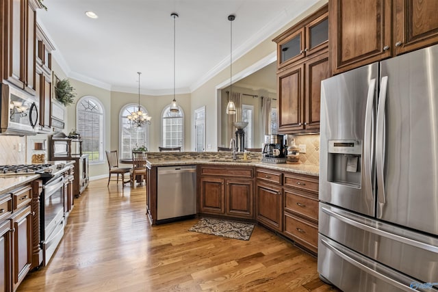 3602 Beason Cove Rd, Steele, AL 35987 - kitchen with a sink, a peninsula, light wood finished floors, stainless steel appliances, and decorative backsplash
