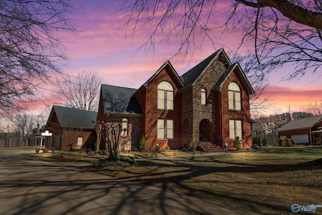 view of front of home featuring stone siding and a front yard