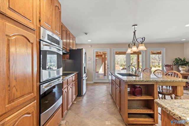 kitchen with open shelves, light stone counters, brown cabinets, and a sink