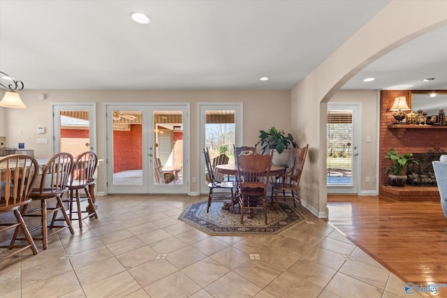 dining room with arched walkways, recessed lighting, a healthy amount of sunlight, and french doors