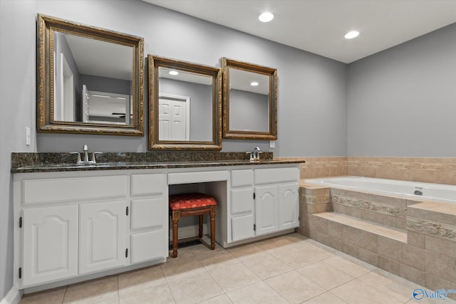 bathroom featuring a sink, double vanity, a bath, and tile patterned floors