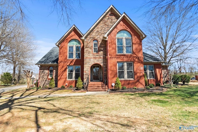 view of front of home featuring stone siding, brick siding, and a front yard