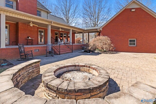 view of patio with ceiling fan and an outdoor fire pit