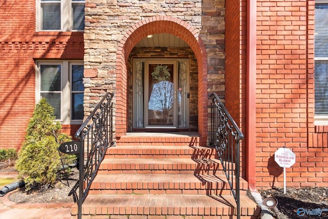 view of exterior entry with brick siding and stone siding