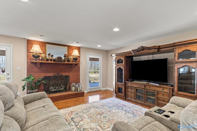 living area featuring a fireplace, plenty of natural light, wood finished floors, and recessed lighting