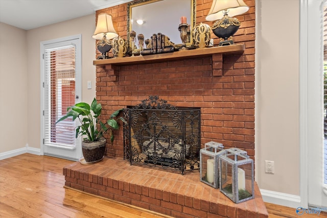 details featuring a fireplace, baseboards, and wood finished floors