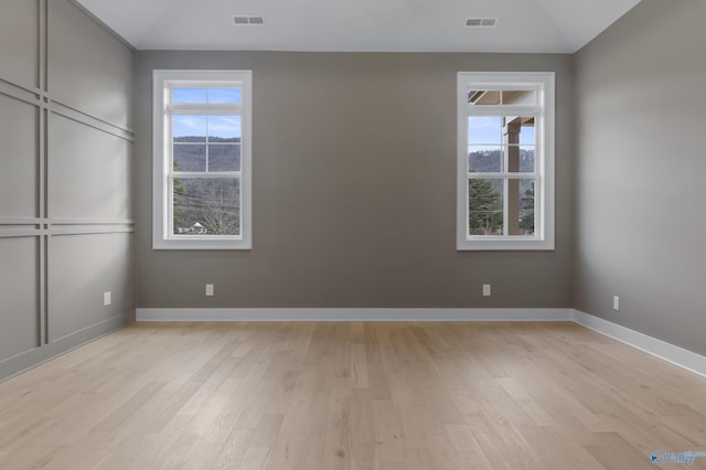 empty room featuring light hardwood / wood-style flooring and a wealth of natural light