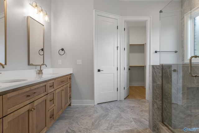 bathroom featuring a shower with door and vanity