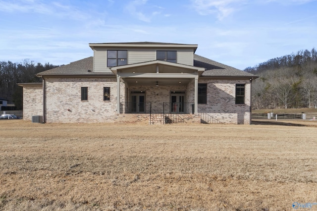 view of front of house featuring a front lawn and central air condition unit