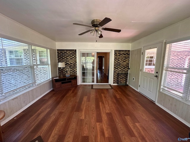 unfurnished living room with a wealth of natural light, ceiling fan, and dark hardwood / wood-style floors