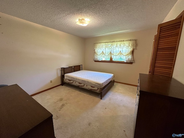 bedroom with light colored carpet and a textured ceiling