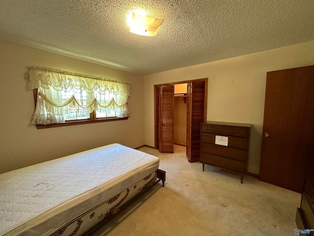 carpeted bedroom featuring a closet and a textured ceiling