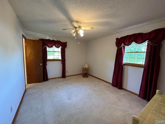 spare room with light carpet, a textured ceiling, and ceiling fan