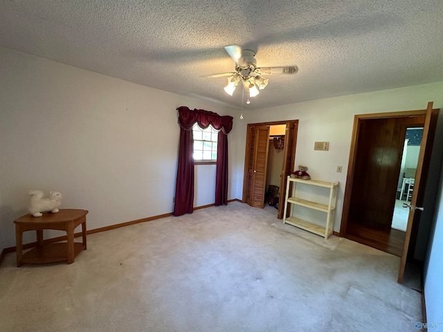 unfurnished bedroom with light carpet, a closet, a textured ceiling, and ceiling fan