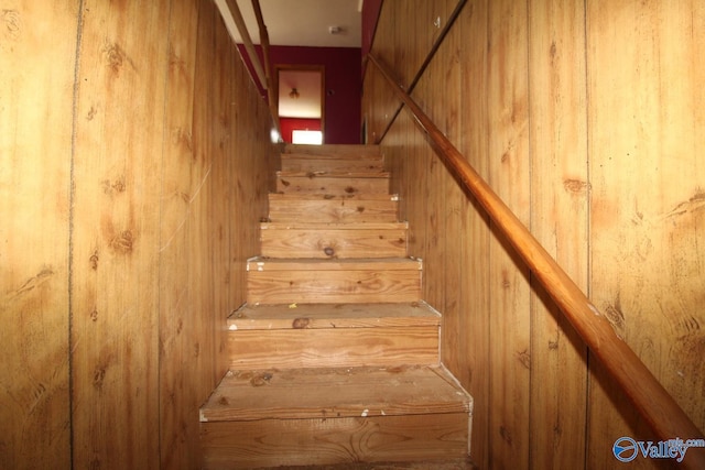 staircase with wood walls