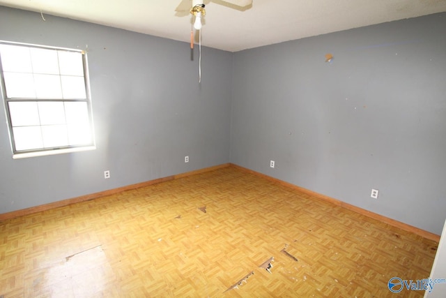 spare room with baseboards and a ceiling fan