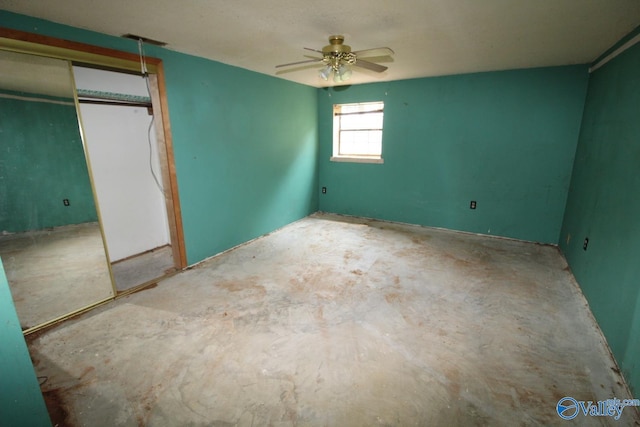 unfurnished bedroom with a closet, unfinished concrete flooring, and a ceiling fan