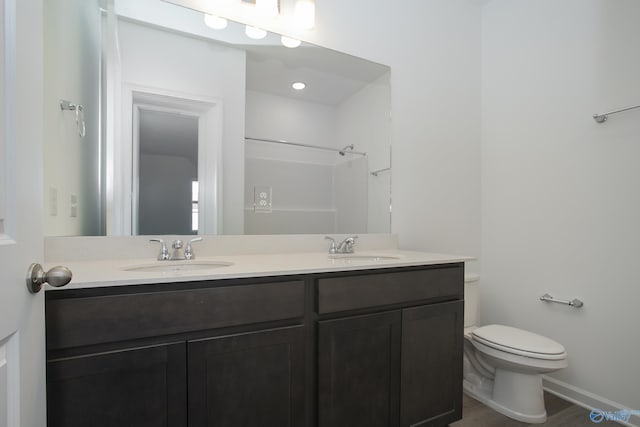 bathroom featuring vanity, toilet, and walk in shower