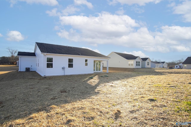 back of house featuring a yard and central AC unit