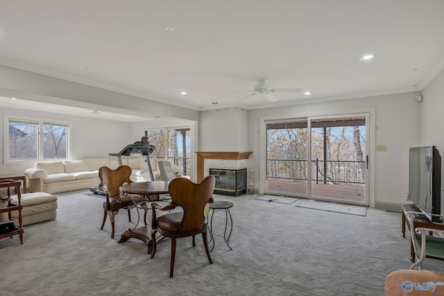 sitting room with light carpet, a wealth of natural light, a fireplace, and crown molding