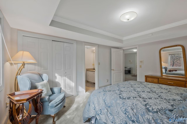 bedroom featuring ensuite bathroom, ornamental molding, light colored carpet, a raised ceiling, and a closet