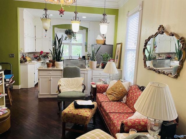 living room featuring dark wood-type flooring, a wealth of natural light, and ornamental molding