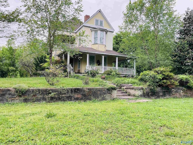 victorian house featuring a front lawn and a porch