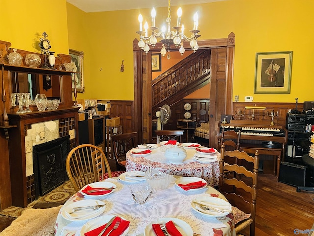 dining area featuring hardwood / wood-style floors, a notable chandelier, and a fireplace