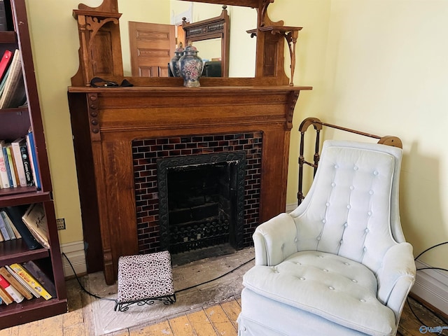 sitting room featuring a tile fireplace and light hardwood / wood-style flooring