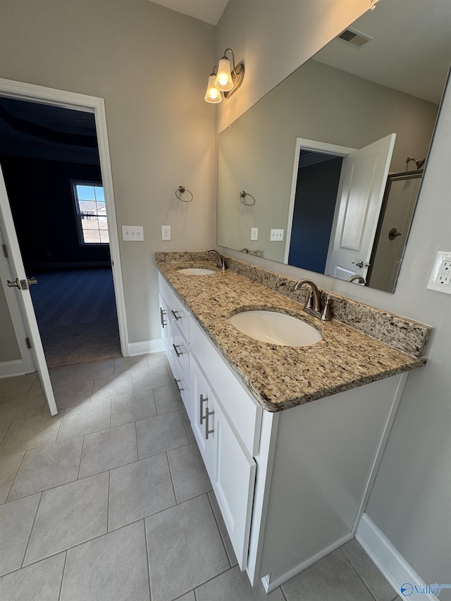 bathroom featuring vanity, tile patterned flooring, and a shower