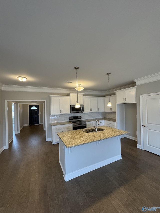 kitchen featuring sink, white cabinetry, decorative light fixtures, appliances with stainless steel finishes, and a kitchen island with sink