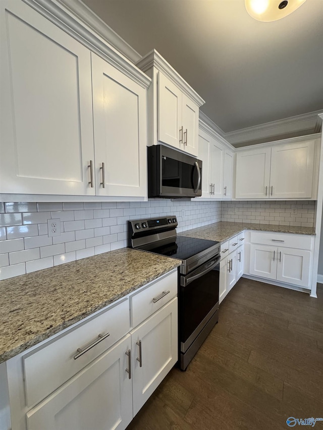 kitchen featuring appliances with stainless steel finishes, tasteful backsplash, white cabinetry, dark hardwood / wood-style flooring, and light stone countertops