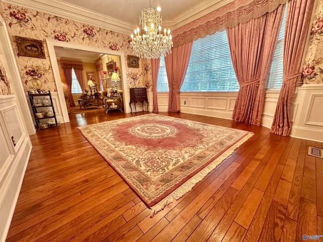 sitting room featuring wood-type flooring, an inviting chandelier, and ornamental molding