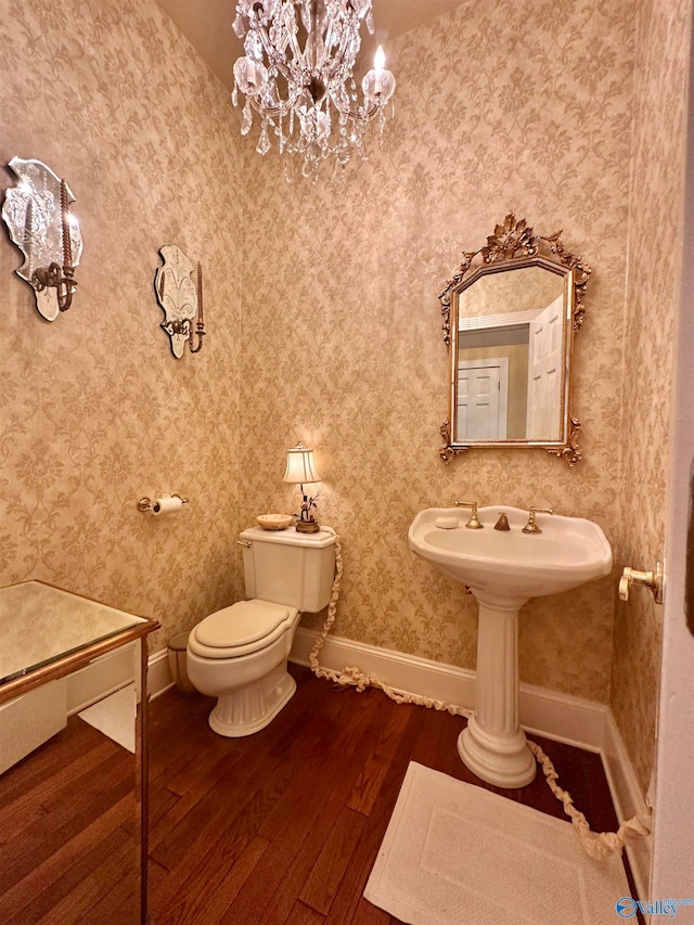 bathroom featuring toilet, hardwood / wood-style floors, and a notable chandelier